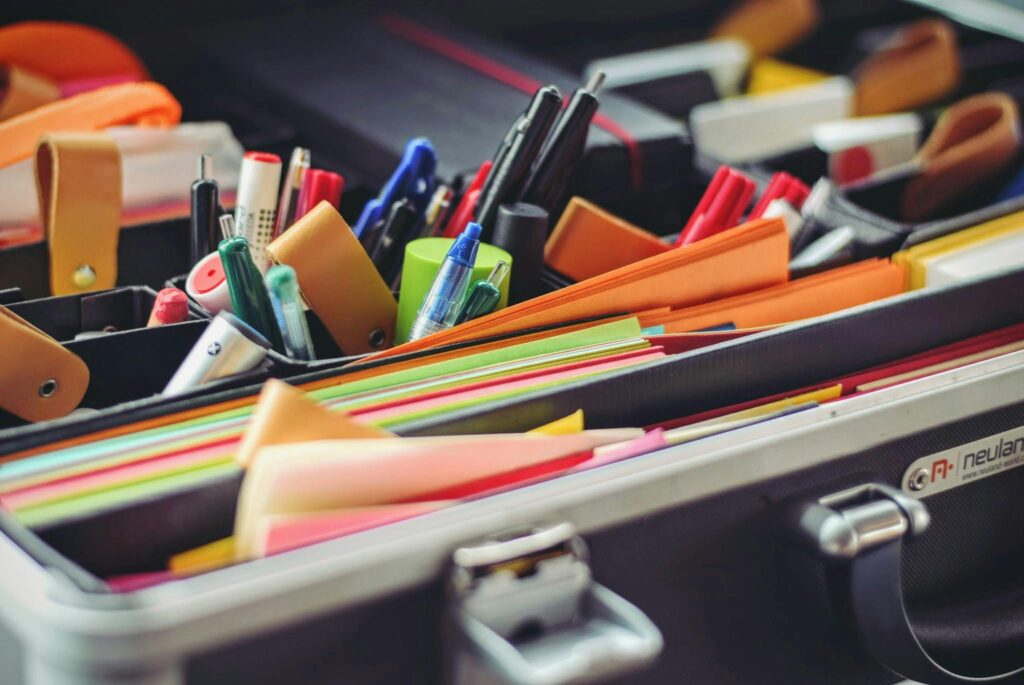 pexels-photo-53874-53874 A collection of colorful office supplies neatly arranged in a suitcase, perfect for professionals on the go.